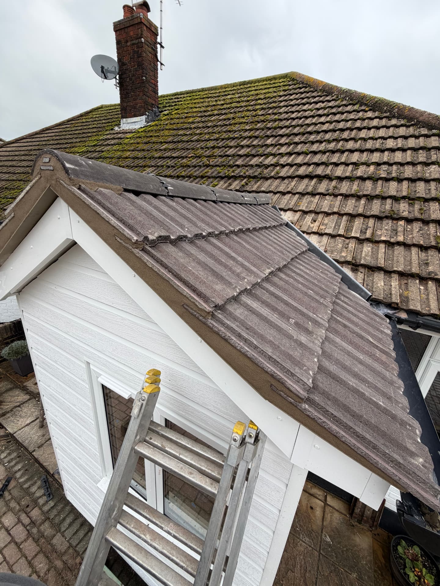 Porch roof re-tiled alongside an existing mossy roof