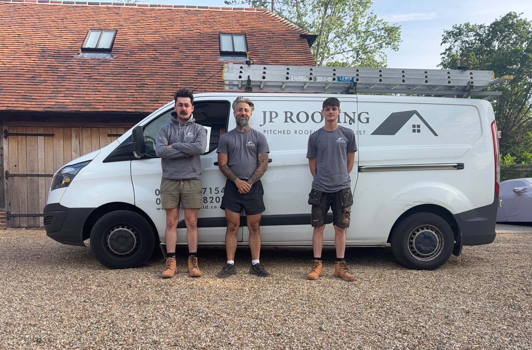 The JP Roofing team standing beside their branded van