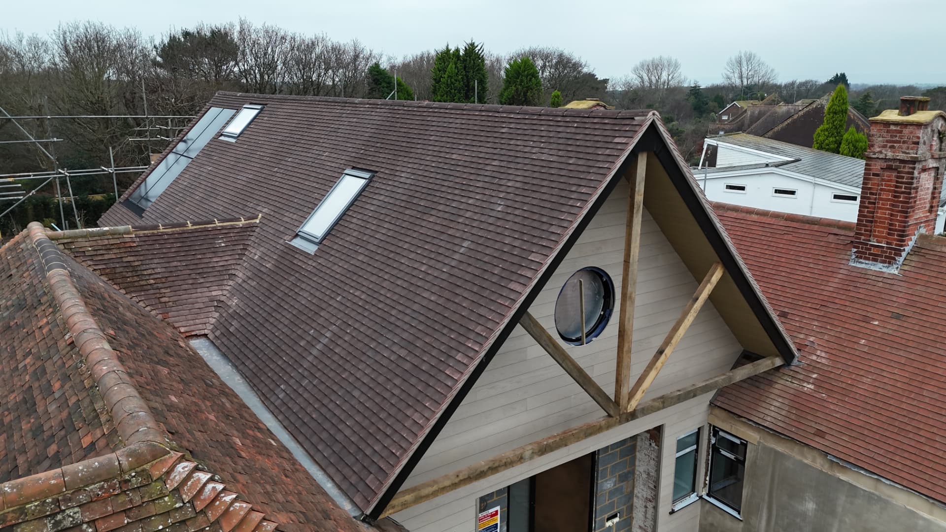 New brown tiled pitched roof with skylights and gable detail